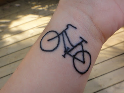 Black ink bicycle tattoo on wrist 