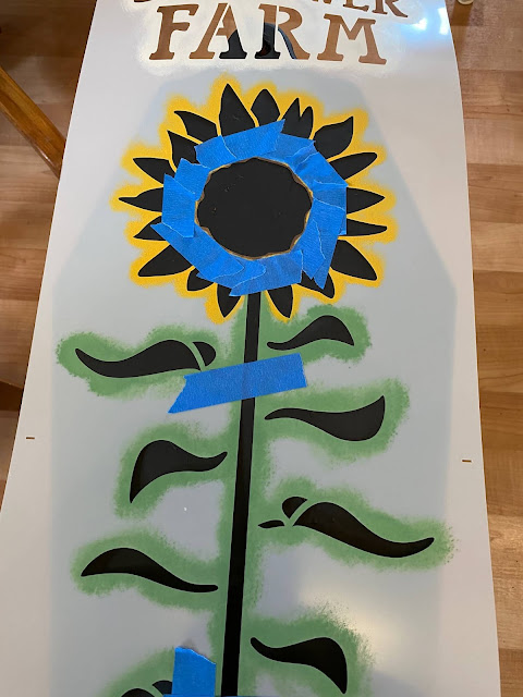 Photo of sunflower stencil taped to prevent flower center's paint from getting onto petals.