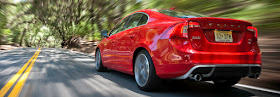 Rear 3/4 view of red 2012 Volvo S60 T6 AWD R SR being driven on two lane road