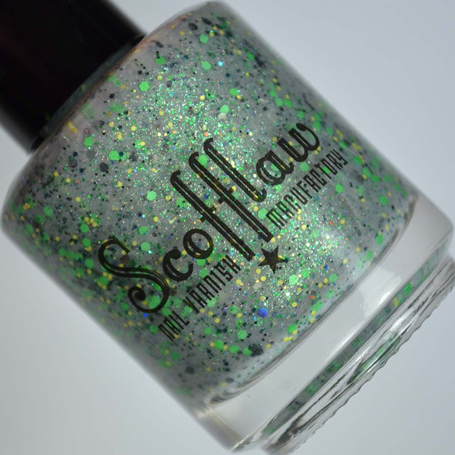 grey nail polish with green glitter in a bottle