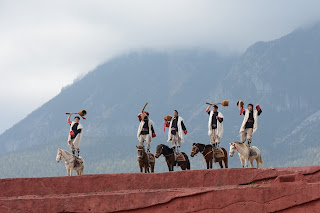 Men standing on horses at Impression Lijiang show