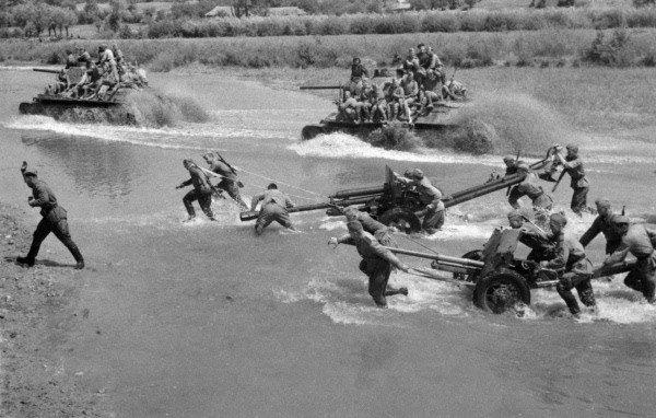 Soviet troops and heavy equipment fording a shallow river in Ukraine, 1944