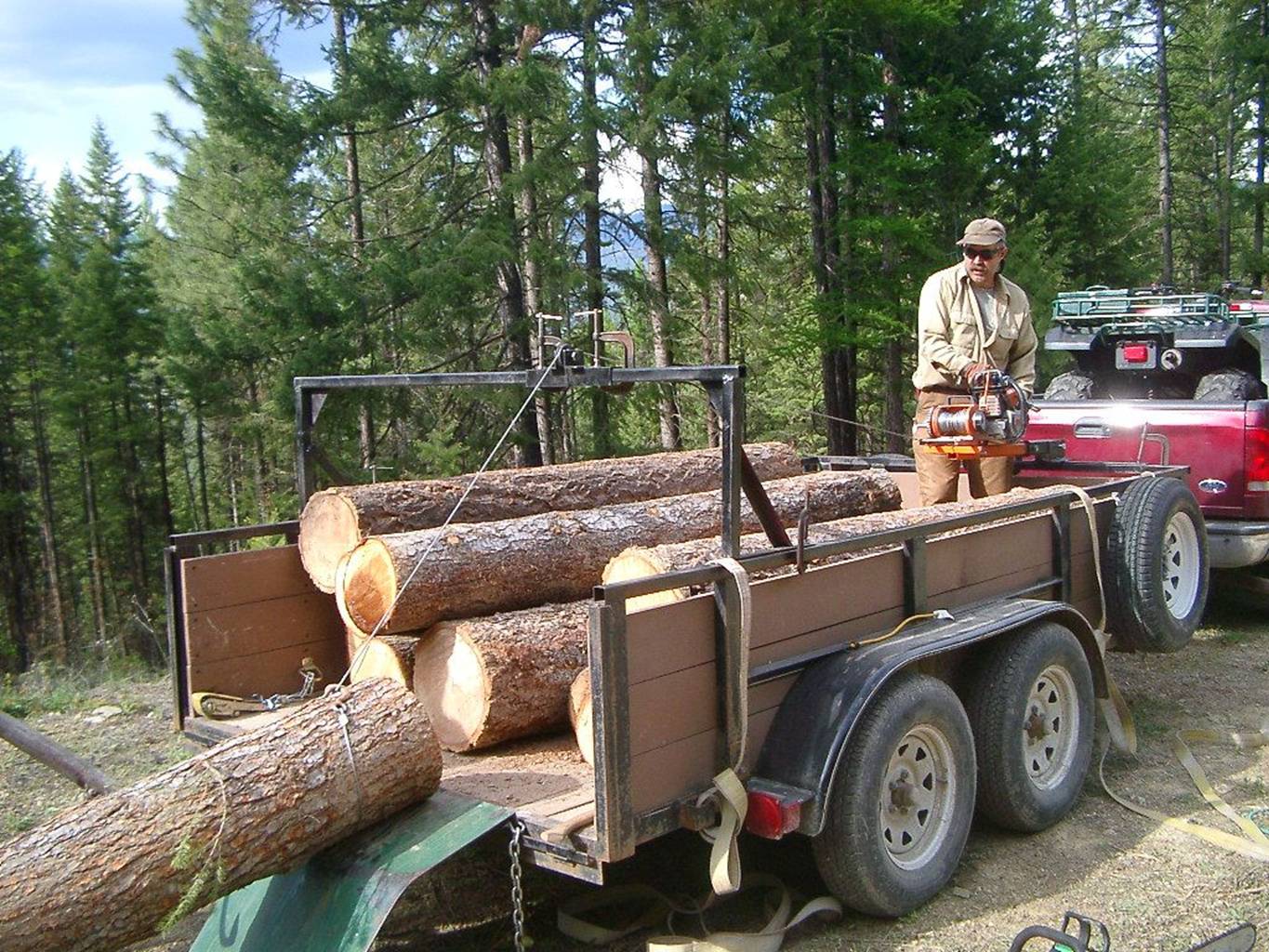 trailer winch site: Lewis Winch loads logging trailer.