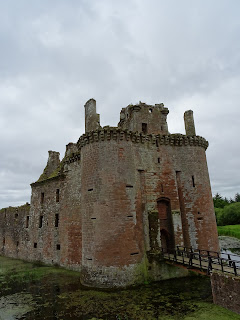 A photograph of the ruins of Caerlaverock Castle showing the front towers and entrance to the castle, along with the drawbridge going over the moat around the castle.  Photo by Kevin Nosferatu for the Skulferatu Project.