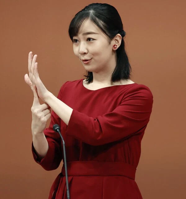 Princess Kako wore an asymmetric ruffled hem burgundy red midi dress in plum. The Princess gave a speech