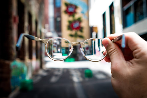 girl holding a pair of glasses