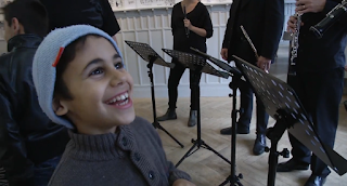 Young participant in El Sistema Söderteälje with musicians from the Royal Stockholm Philharmonic