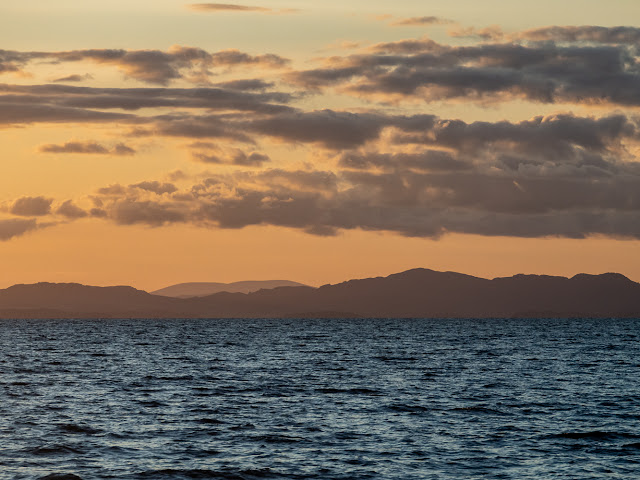 Photo of the sun setting over the Scottish hills from the Solway Firth