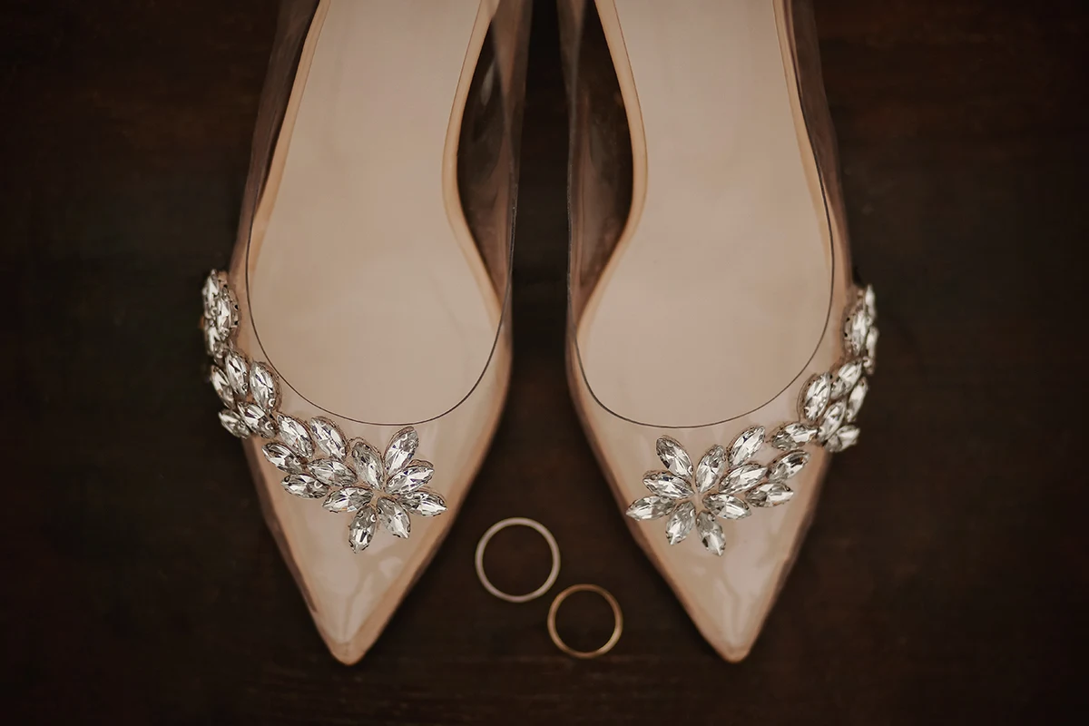 a pair of wedding heels close to the rings