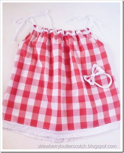 Red and white gingham print pillow case dress for baby, with matching headband.