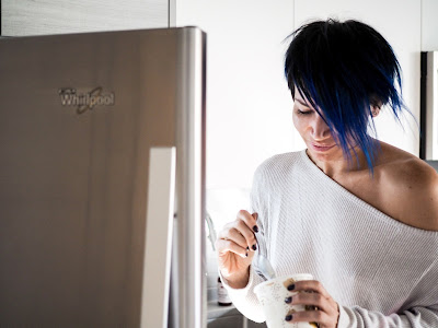 Mujer delante de una nevera comiendo un helado