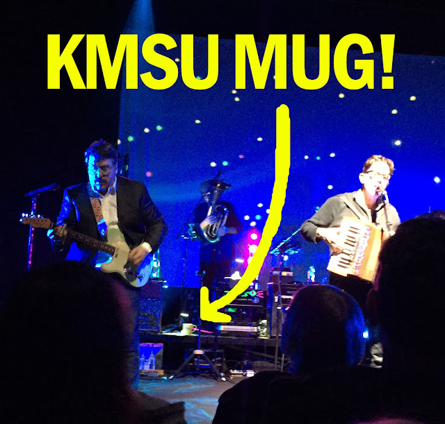 They Might Be Giants on stage with KMSU mug