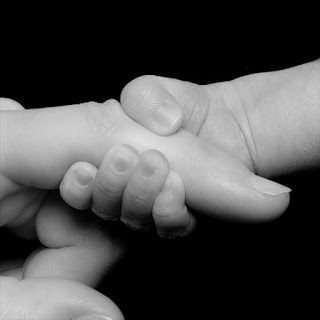 Newborn holding onto a finger