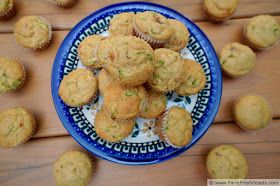 photo of a plate of peach & zucchini muffins on a table, with muffins scattered around