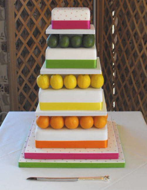 A true rainbow wedding cake made up of 6 round tiers each tier is iced in 