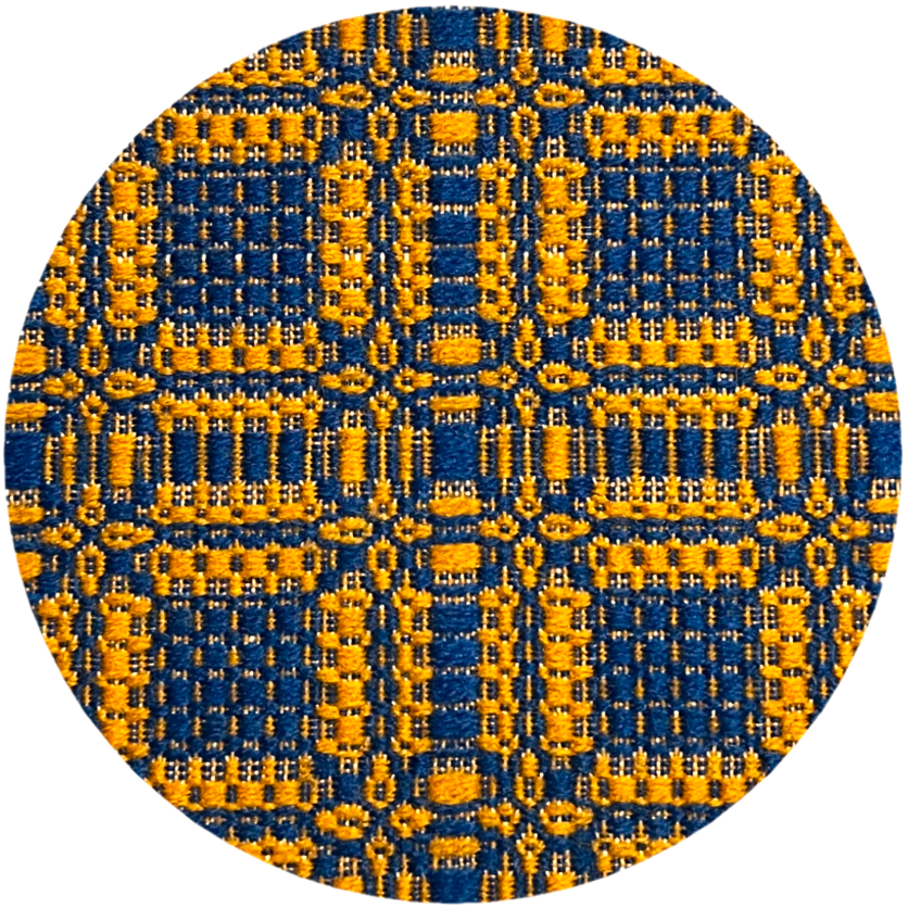 A patterned weaving of squares and rectangles in blue and orange against a background of tan warp threads