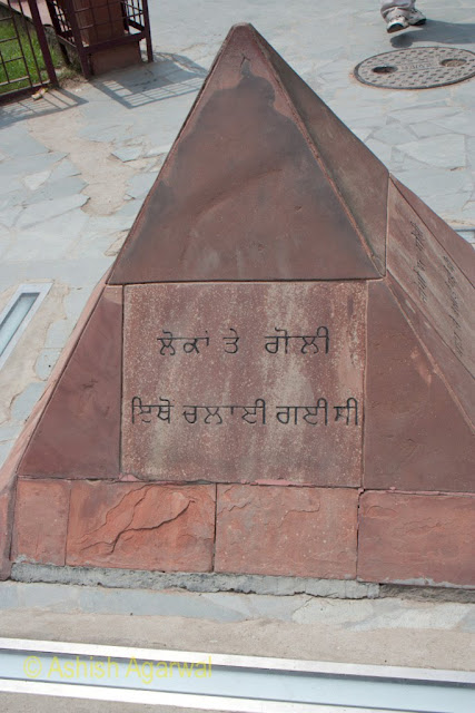 Close up of the Gurmukhi script on the stone in the Jallianwala Bagh Garden in Amritsar from where soldiers fired