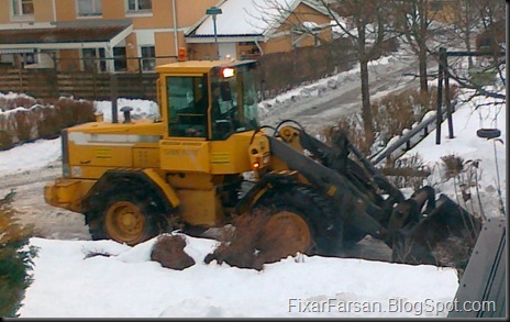 Hjullastare skrapar gatan från snö 1