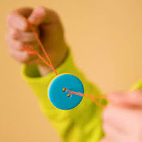 Child playing with a button on string
