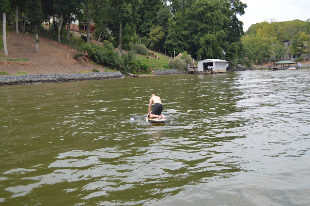 Dad trying to stand on the paddle board.