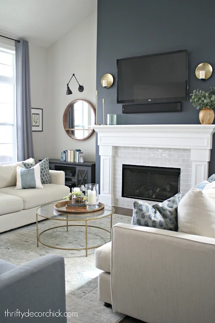 Dark wall, white fireplace surround, gray tile