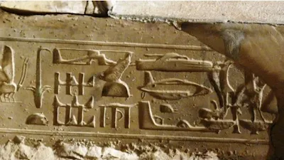 A stone carving of a submarine and helicopter plus other machines in an ancient tomb from a pharaoh in Egypt.