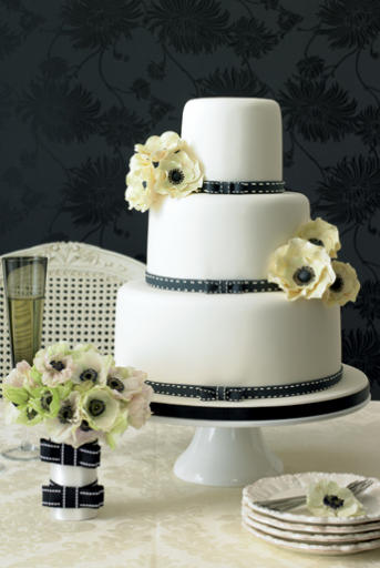 Elegantly romantic 3 tier wedding cake with white frosting black ribbon