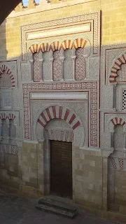 the mezquita de córdoba with the sun rising and shining on the walls