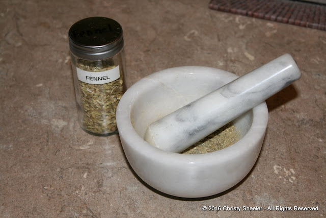 Grinding the fennel seed with a mortar and pestle. 