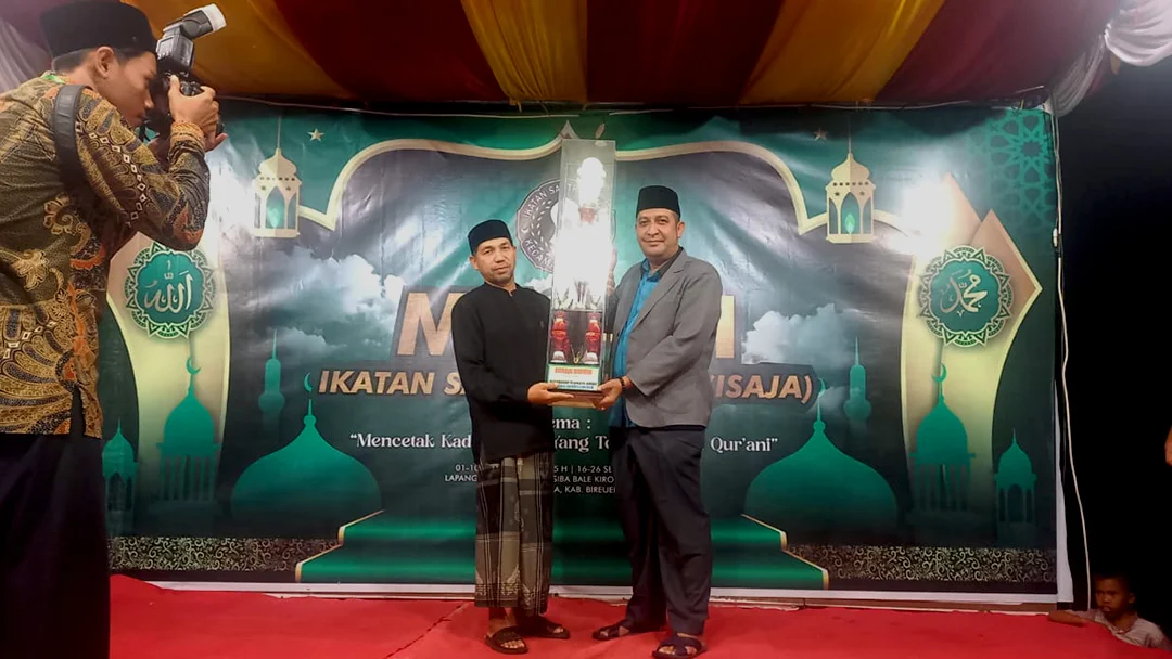 Penyerahan Piala Umum MTQ ke-III ISAJA oleh Dr. Nazaruddin Abdullah, MA (kanan) kepada Pimpinan Dayah Baitul Faizin Al-Aziziyah, Tgk. H. Fauzan (kiri) pada Selasa (26/09/2023) malam.