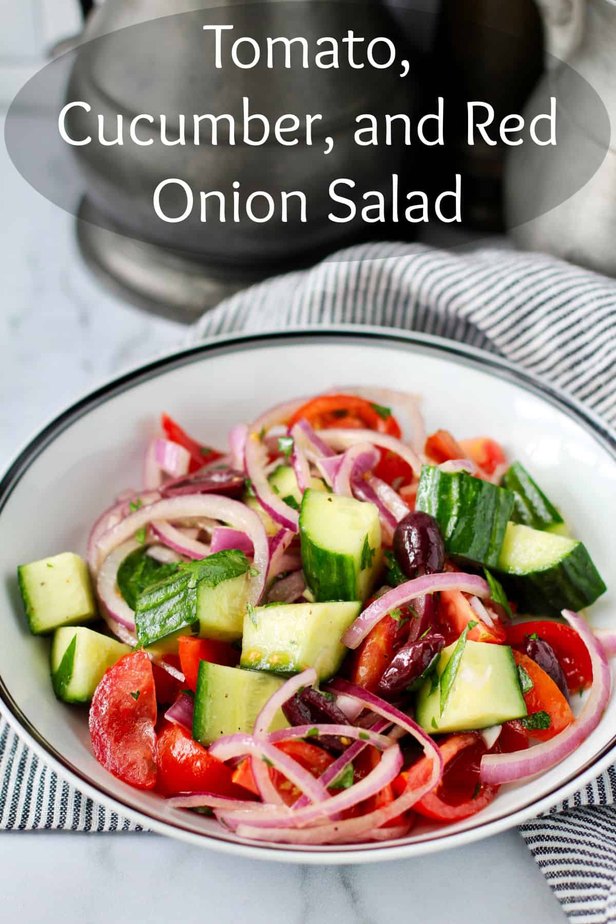Tomato, Cucumber, and Red Onion Salad with Latholemono Dressing in a dish.