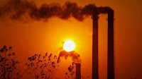 Smokestacks at sunset (Credit: Reuters) Click to Enlarge.