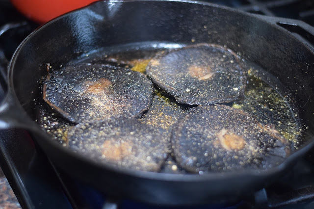 The pressed mushrooms in the cast iron skillet, seasoned with the spices.