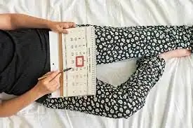 menstrual irregularities.  A young lady carrying a calendar with the day of the week noted