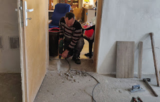 Bekir chiselling out the cement from the kitchen side of the door