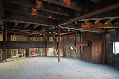 A low room with extensive woodwork on the ceiling and a 'beam' running across at shoulder height.