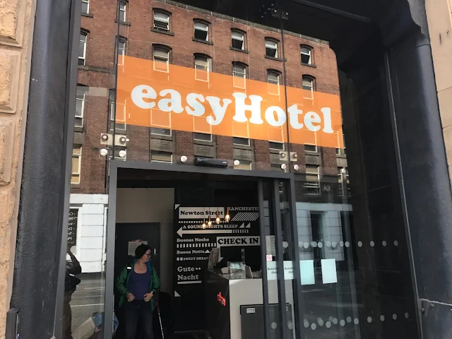 A glass door with easyHotel written above it and a view into a small reception area