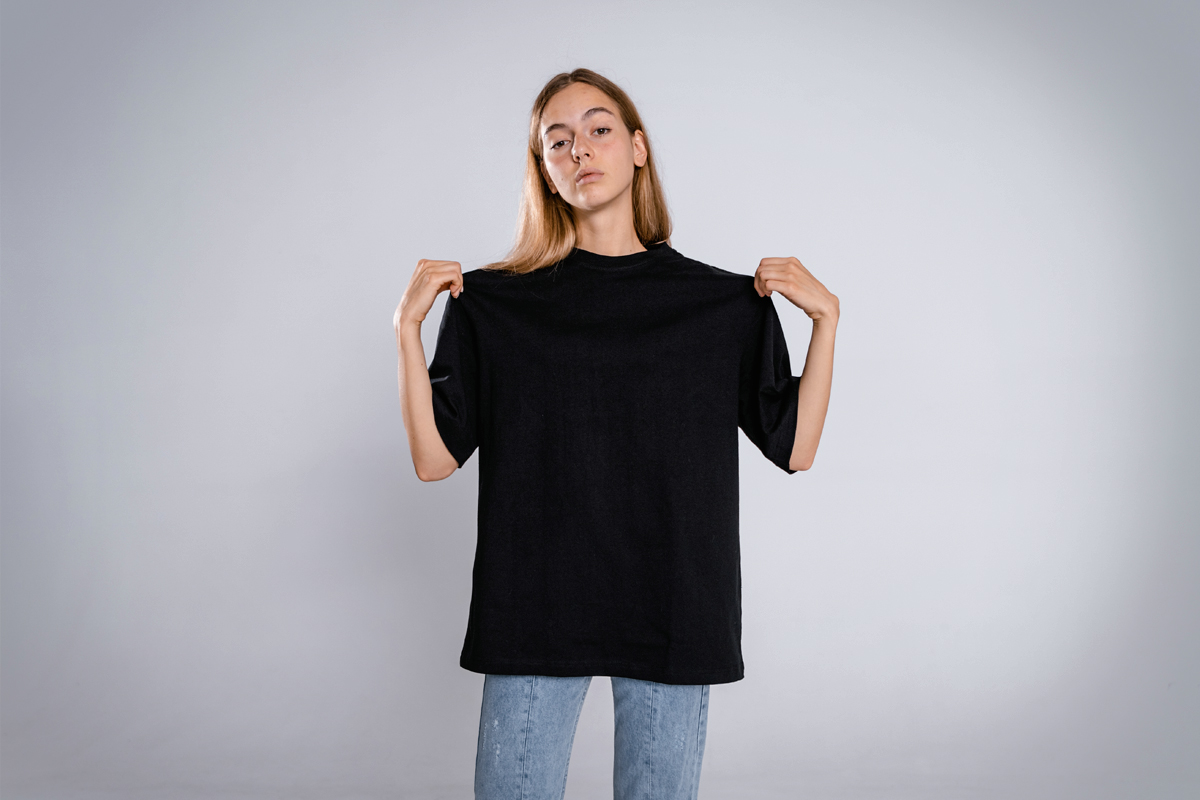 young woman in black t-shirt is posing in a studio