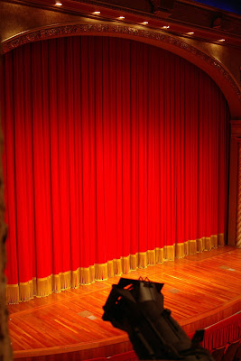 image of a red curtain closed in front of a stage