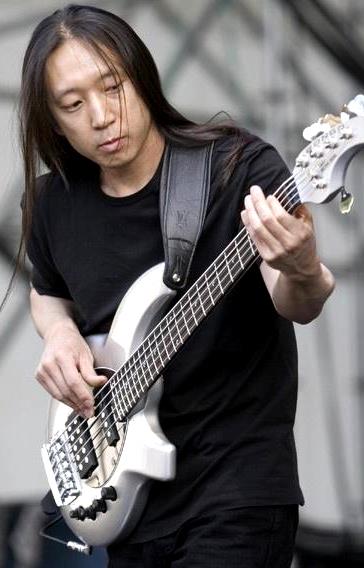 Foto de John Myung tocando concentrado en concierto