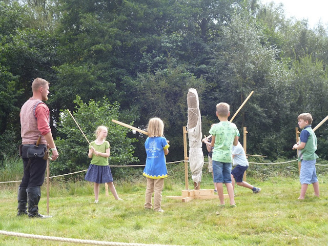 children at a medieval festival learning sword skills