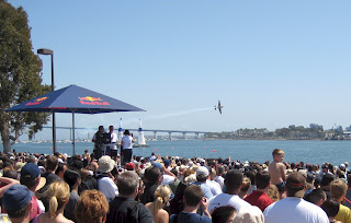 Race Plane flying out of a Blue Gate past the Announcers Stand.