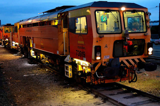 night photo of uk railway track tamper machines 73919 and dr73925 at ely station 2014