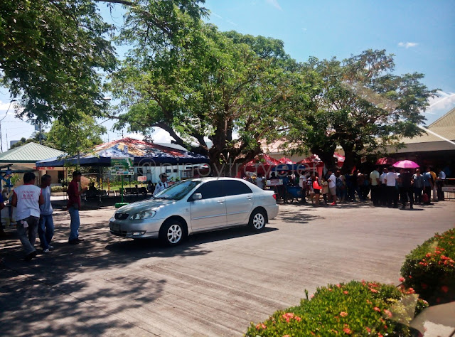 well wishers and drivers under a tree at tuguegarao airport arrival area