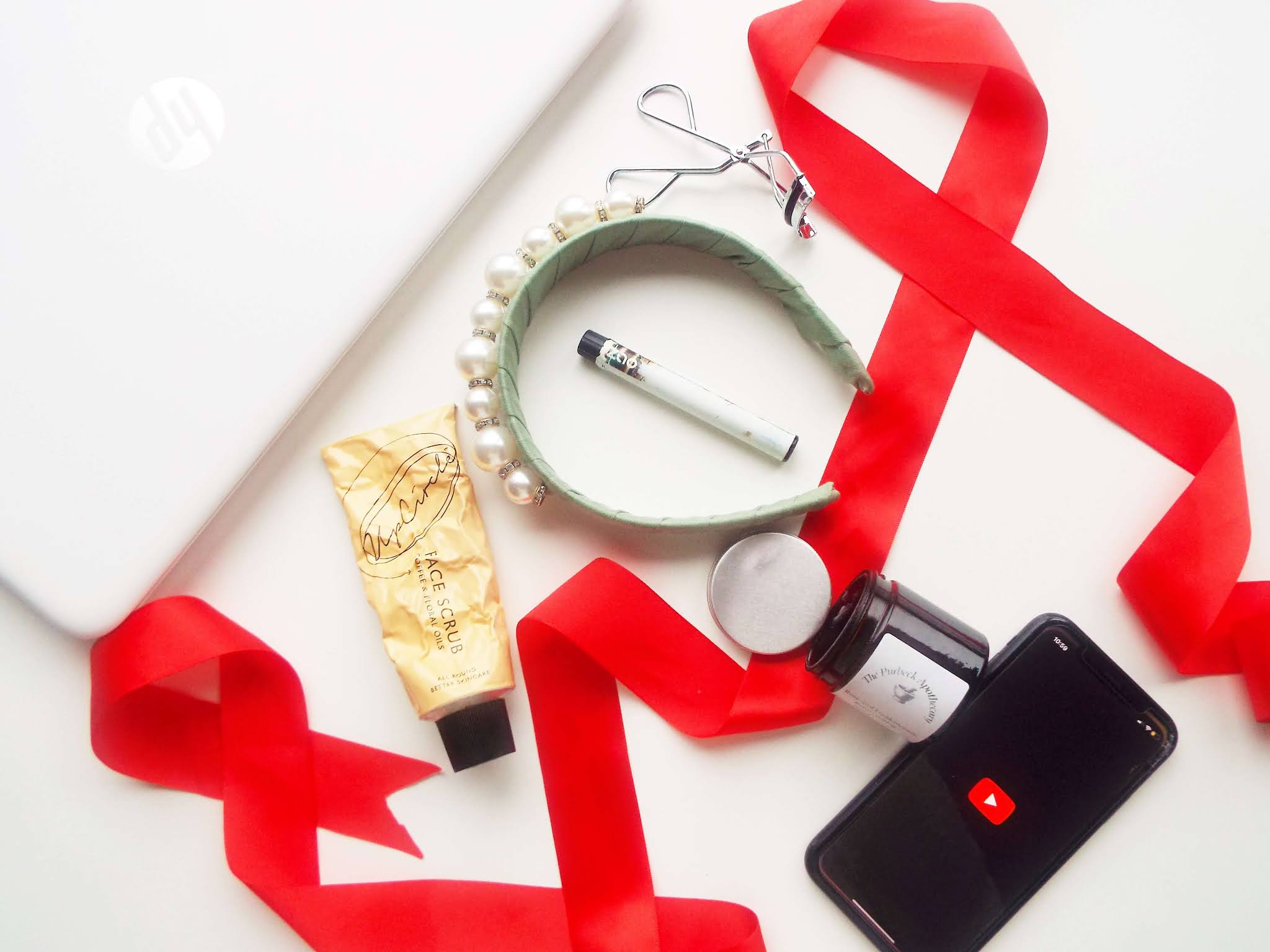 Flatlay of my January 2021 monthly favourites, including beauty, makeup, fashion, food and lifestyle. Decorated with red ribbon.