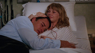 Jen holding Jack in her arms as they lay together in her hospital bed