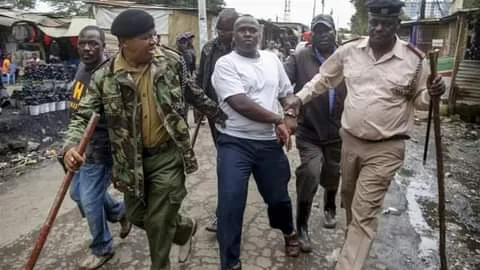 Kaloleni Police officers arresting resident with no facemasks