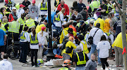 Medical workers aid injured people at the finish line of the 2013 Boston . (boston marathon )