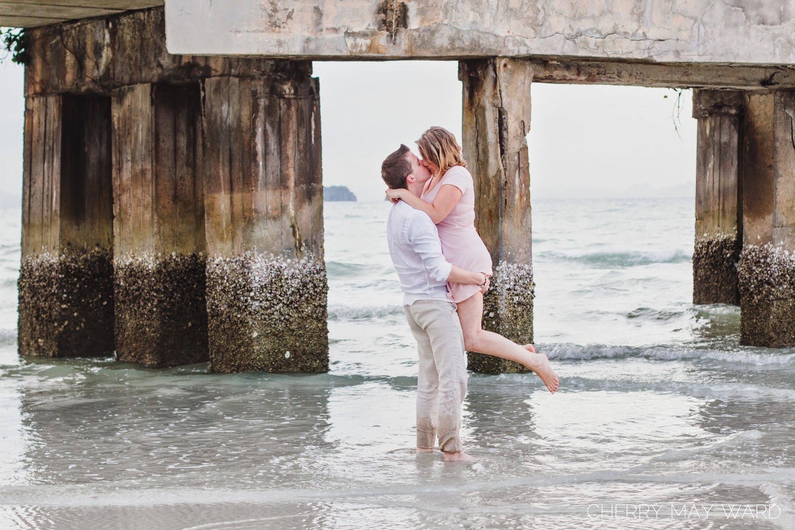 happy couple kissing on the beach, kissing at a pier on Koh Samui, engagement photographer Koh Samui, Thailand wedding photographer
