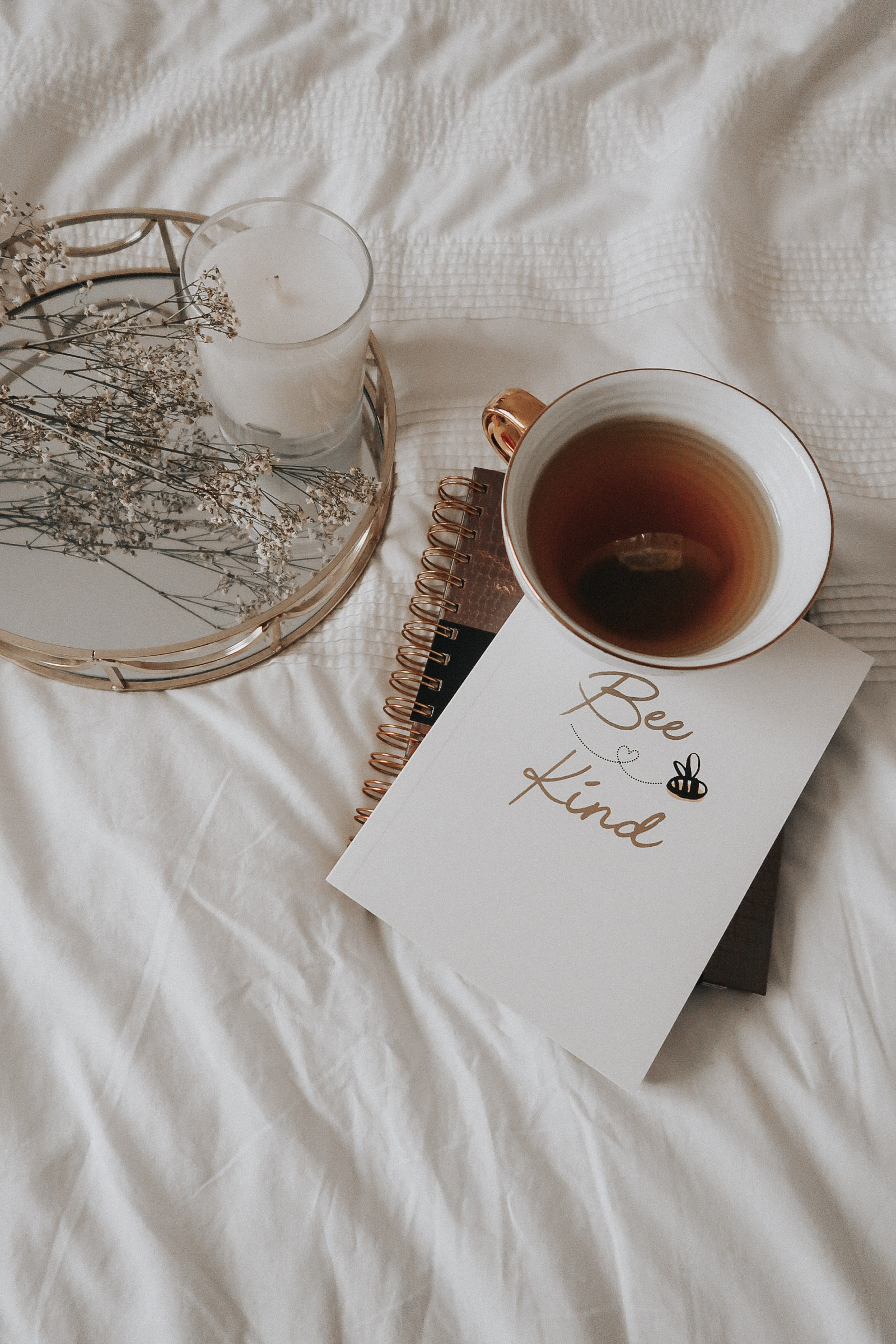 A flatlay of a notebook and white mug.